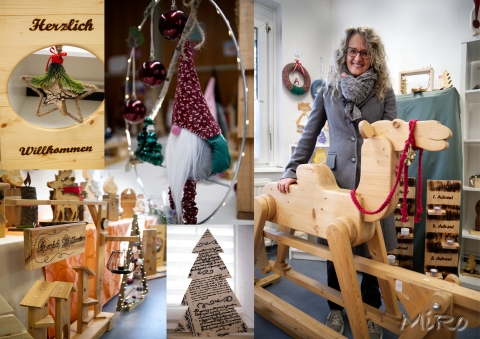 Collage mit weihnachtlichen Holzdekorationen, einem Schaukelkamel, Sternen und Wichteln. Eine Frau lächelt inmitten festlich dekorierter Handwerkskunst. © Michael Romano