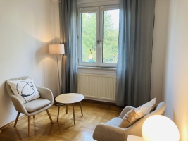 Foto Raum 2 der Praxis: Stuhl, Tischchen und kleines Sofa