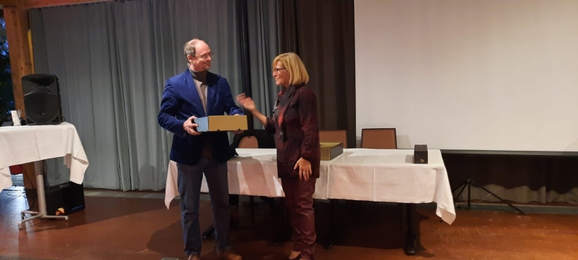 Übergabe eines Dankeschöns von Andrea Reisinger an Martin G. Sellner.