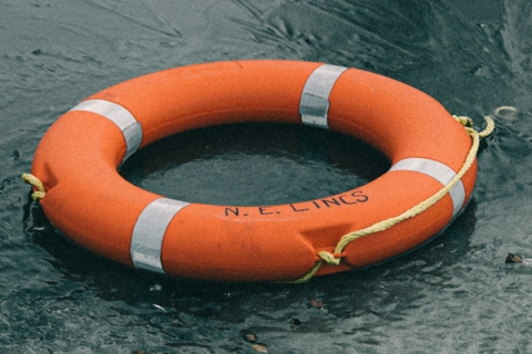 Foto eines im offenen Meer treibenden orangen Rettungsrings